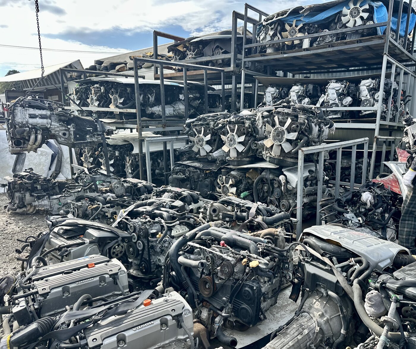 Used engines stored on metal racks and on the ground in the yard