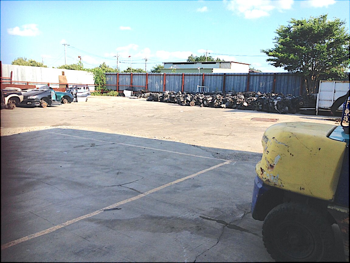 Yotsukaido Industrial Yard — paved work yard with equipment and parked vehicles