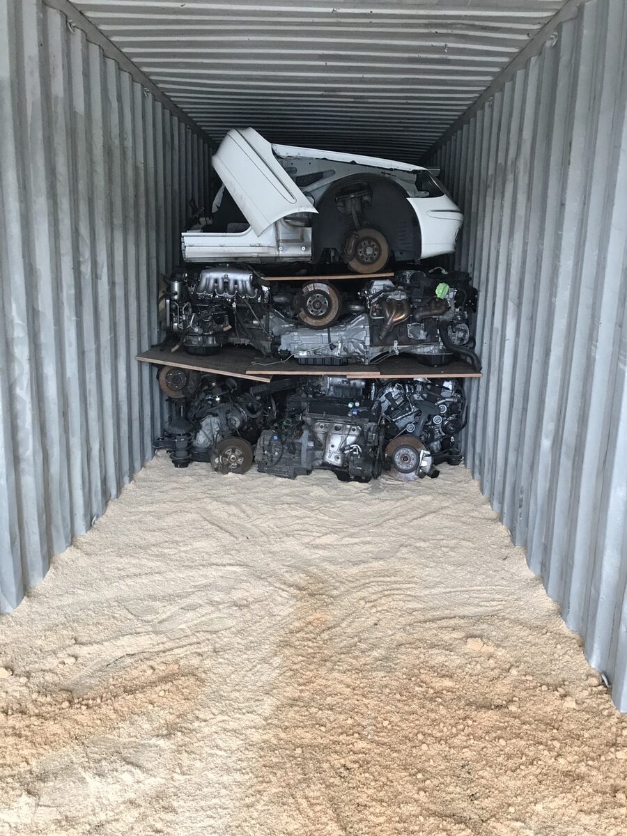 White vehicle section and engines at the far end of a container
