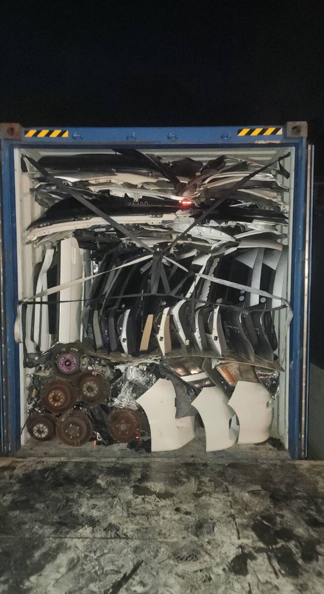 Used auto parts stacked inside a shipping container
