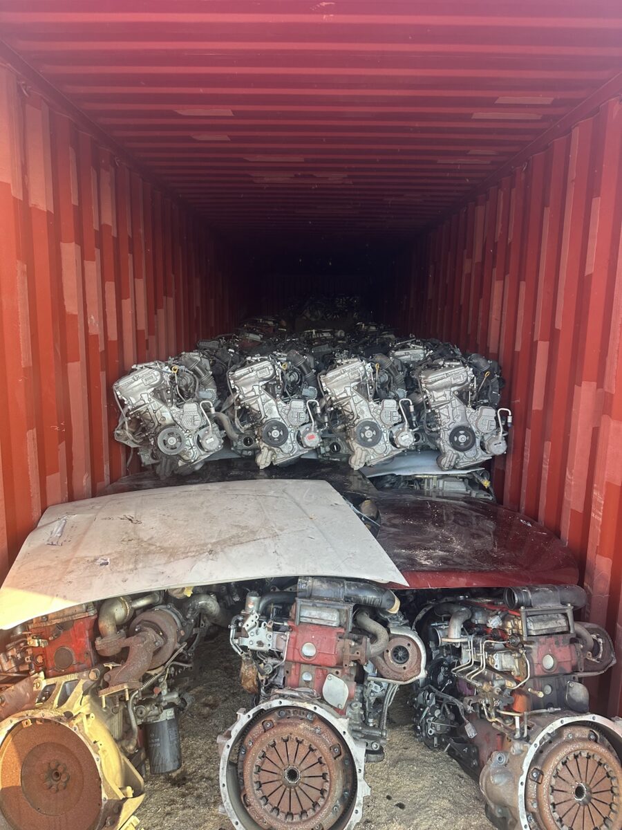 Engines separated by a wooden platform in a red shipping container