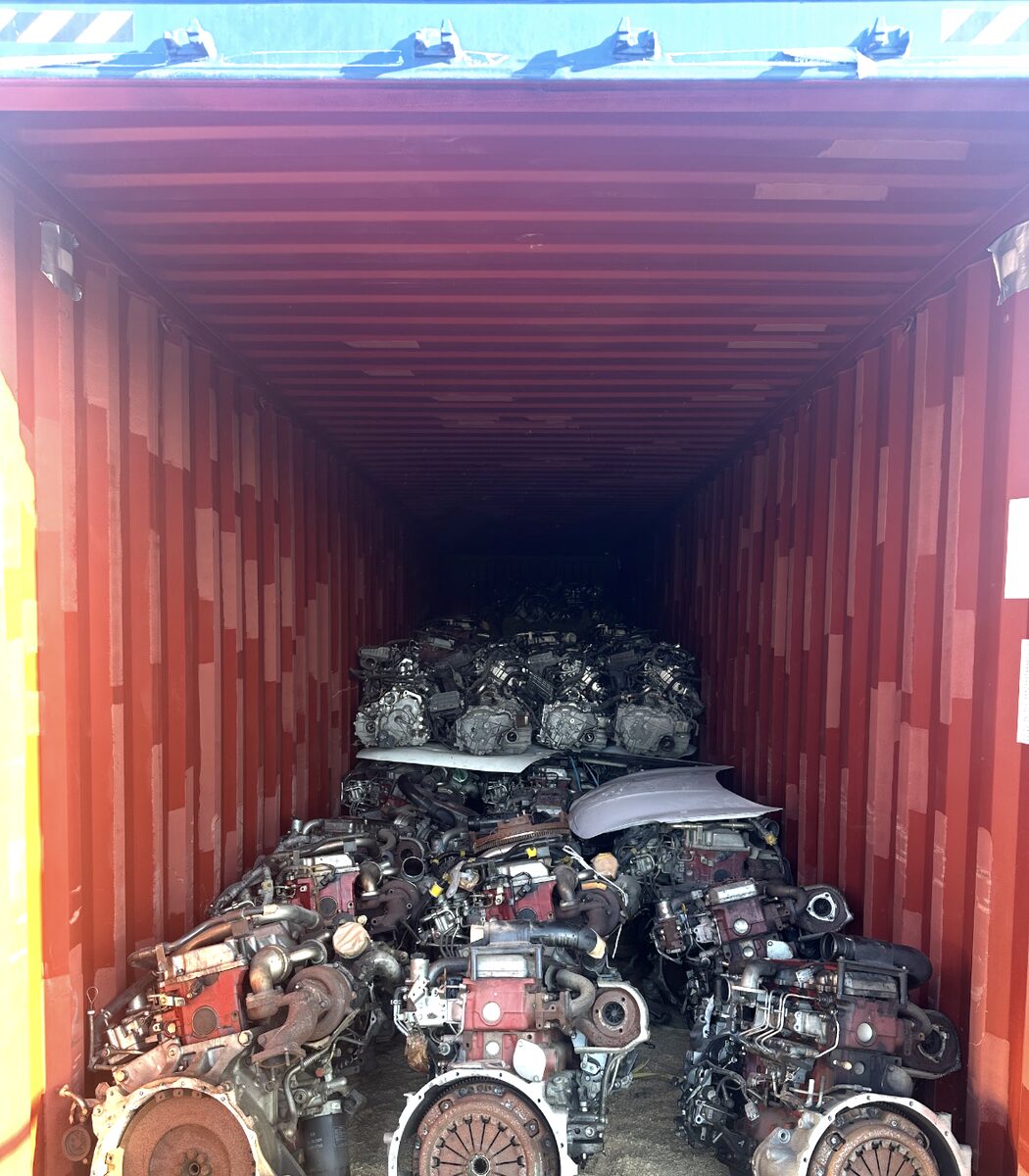 Rows of engines on the floor of a red shipping container