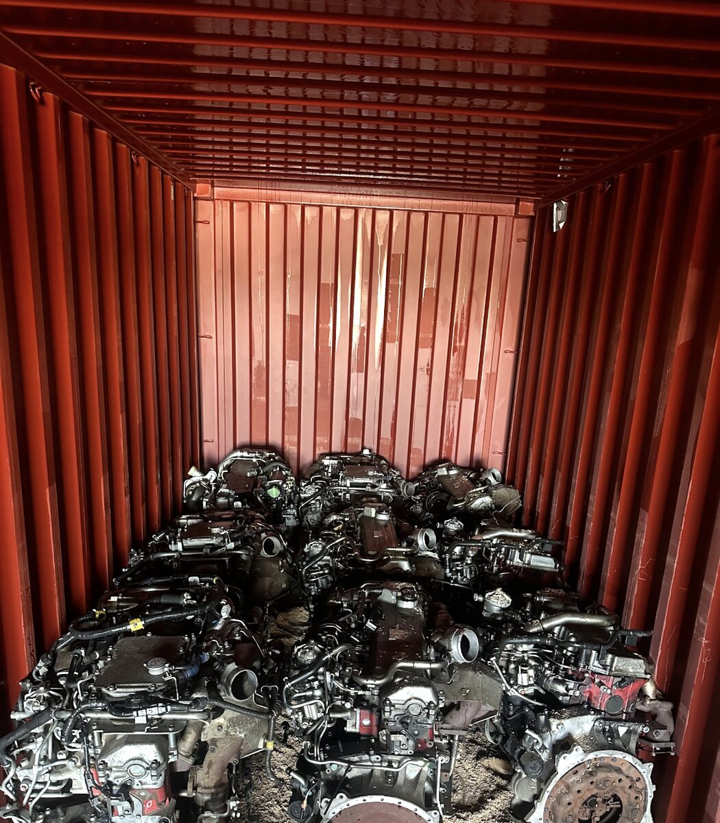 Engines packed along the floor beneath red container walls