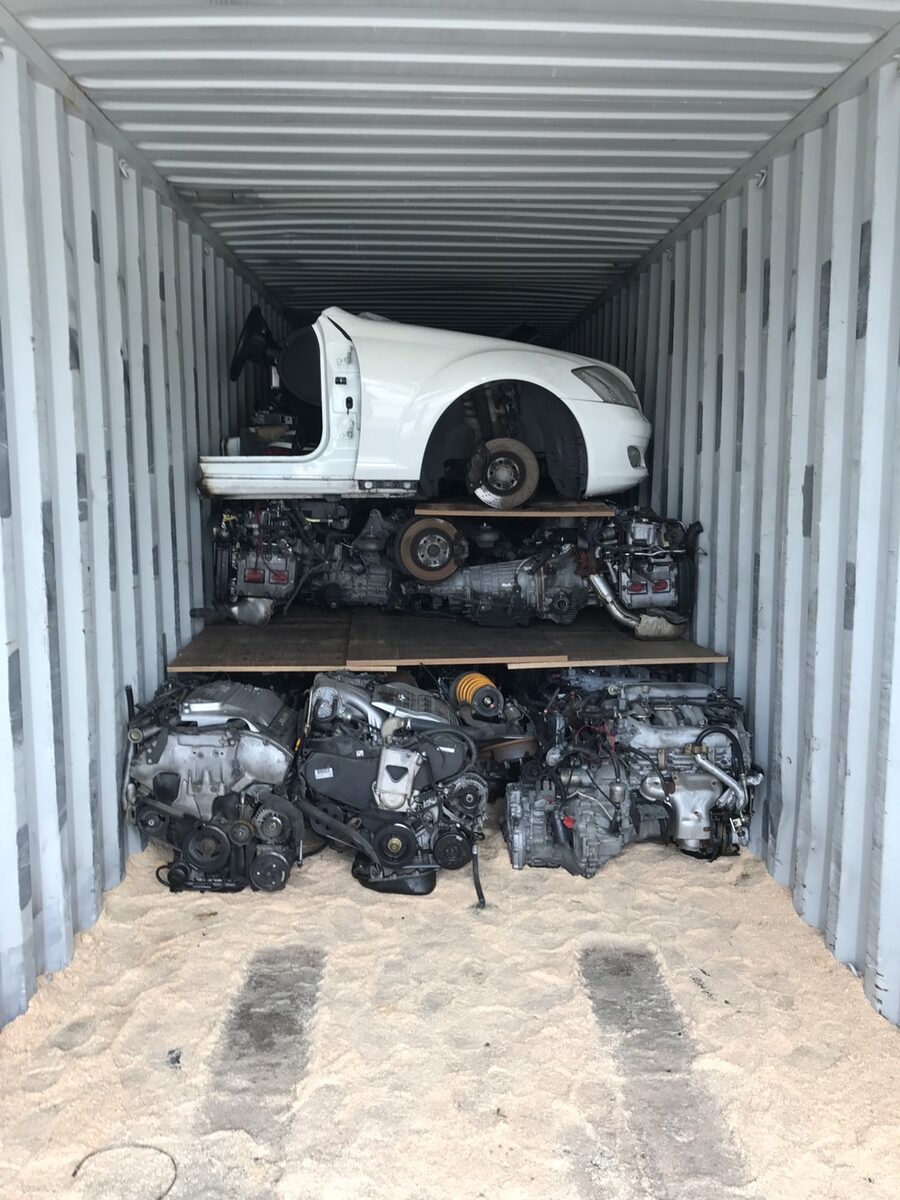 White vehicle front section above engines, with an open plywood loading floor