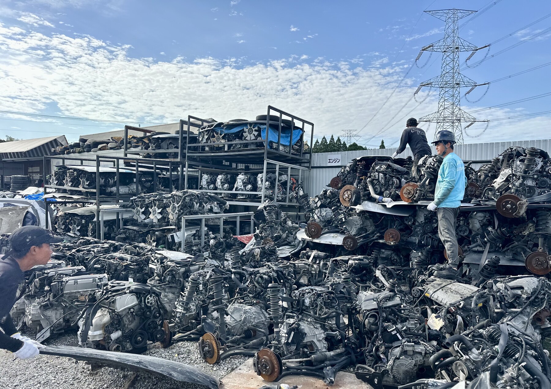 Workers beside rows of engines in the outdoor yard