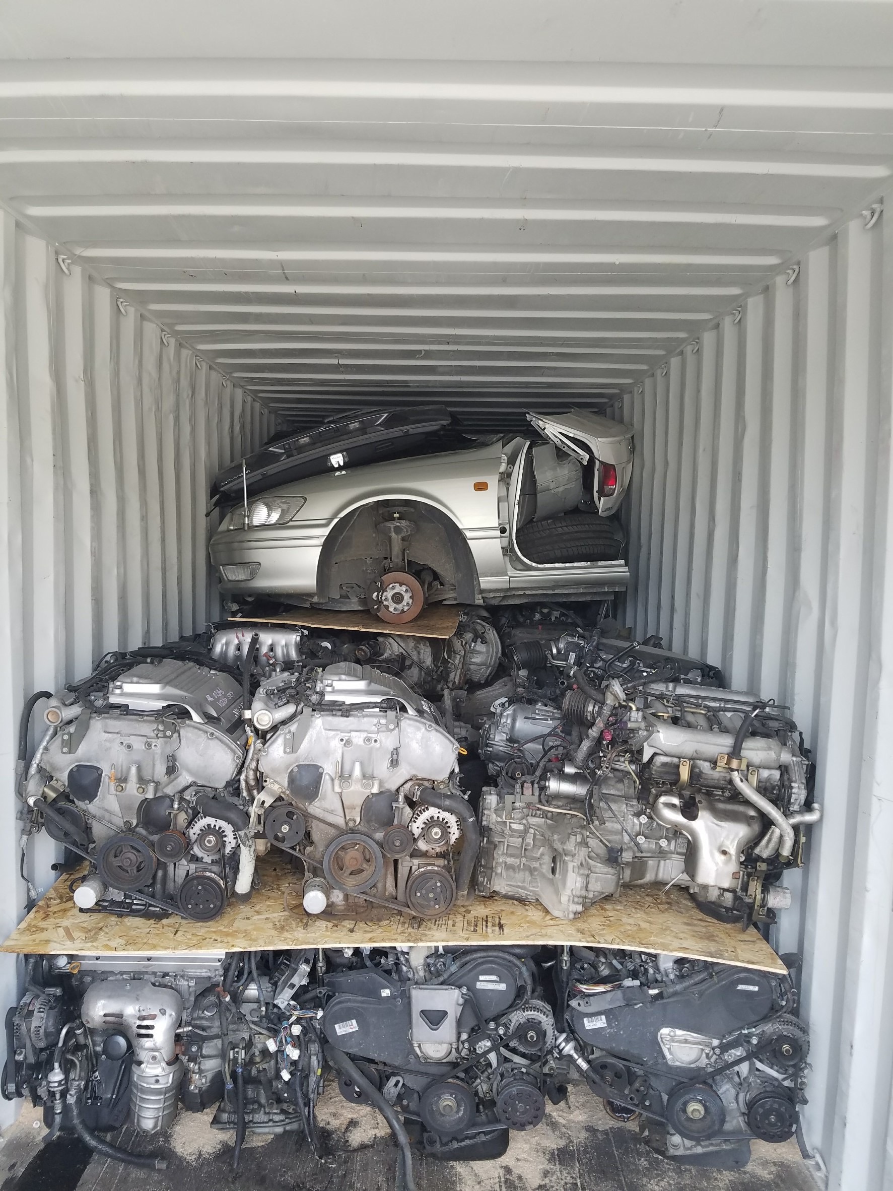Used engines and part of a car loaded inside a shipping container