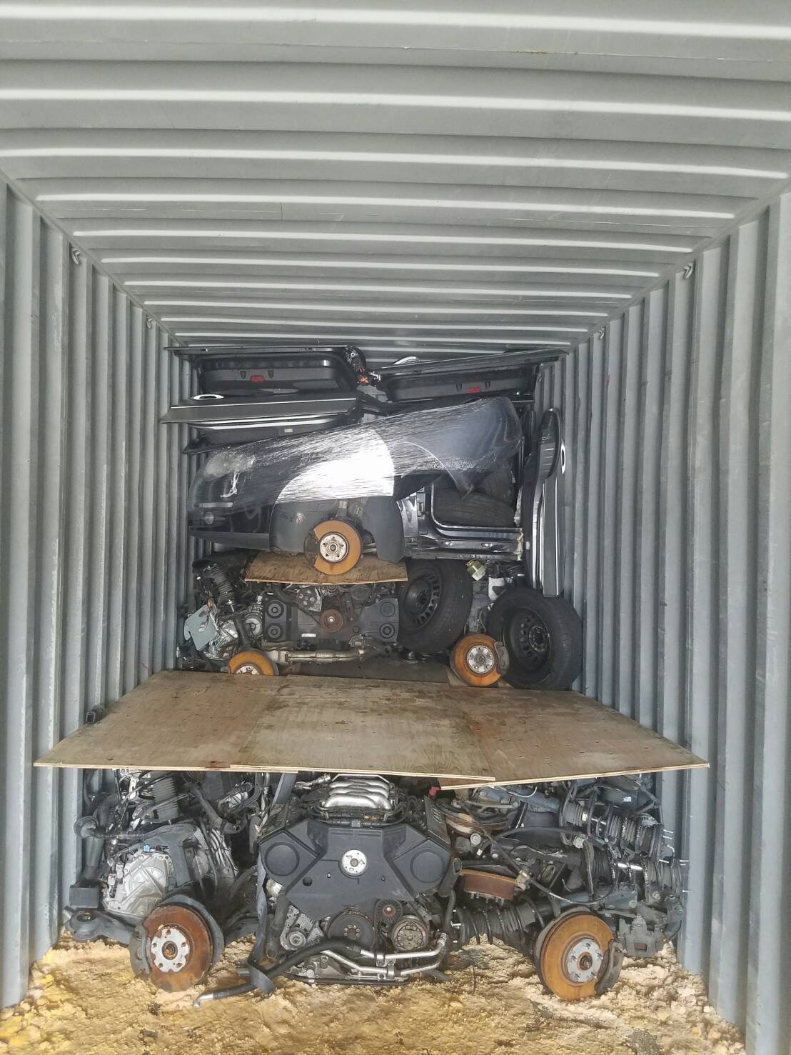 Used engines and vehicle parts stacked inside a shipping container